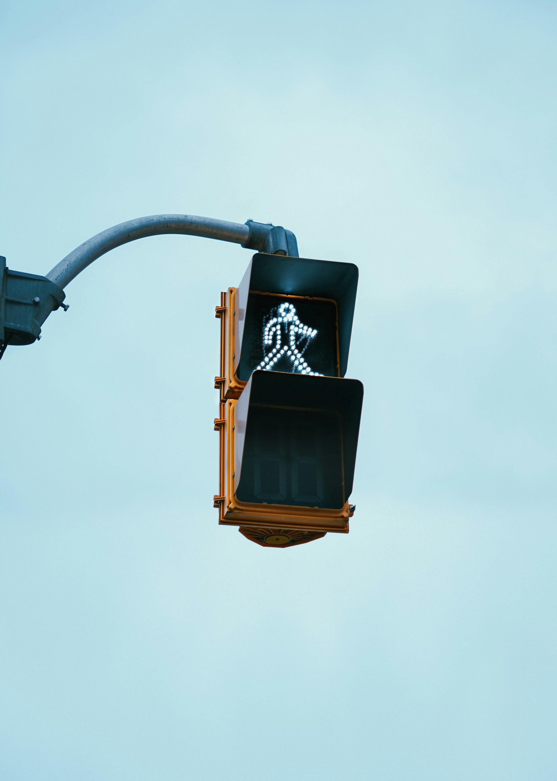 An illuminated pedestrian crossing signal against a clear sky — a visual cue for the trust signals that guide a visitor's decision